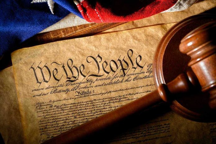 1650343750 Gavel on U.S. Constitution with flag backdrop.