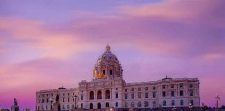 Historic building with dome under a pinkish-purple sky.
