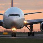 Airplane on runway during sunset.