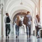 ILLEGAL University SHUT DOWN—Governor Takes Action Four students walking in a corridor together.