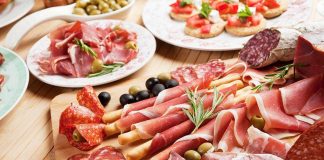 A beautifully arranged charcuterie board featuring various cured meats and olives
