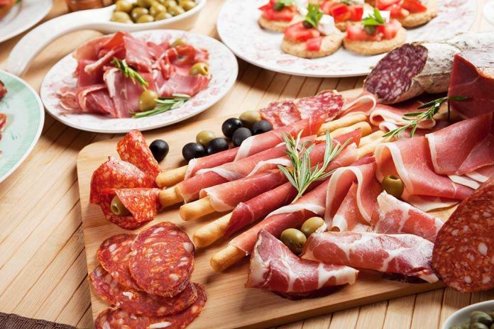 A beautifully arranged charcuterie board featuring various cured meats and olives