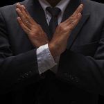 eBay’s Bold Move: Refused $56B GameStop’s Bid A man in a suit crossing his arms in a gesture of refusal or rejection