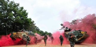 Army’s Balloon Gambit—Real Firepower? Soldiers running from armored vehicles with red smoke.