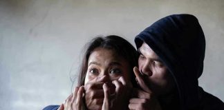 9 Teens Convicted of Gang Rape — Walk Free Without a Single Day in Jail Man holding womans mouth, gesturing silence.