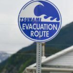 Monster Quake Slams Mindanao — Tsunami Panic Sign indicating tsunami evacuation route with a wave graphic