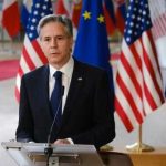 The Iran Peace Announcement — And Why “Immediate” Isn’t Actually Immediate Man in suit speaking at podium with international flags behind
