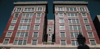 Consent Or Coercion? Pakistan Court Rules Dallas County Criminal Courts building facade with worker on lift