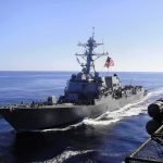 naval destroyer sailing at sea with flag flying