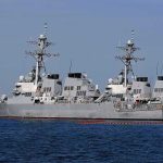 Hundreds Of Strikes—Did War Just Start? Three gray naval destroyers docked side by side at a pier