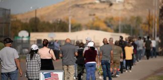 Court Clash: Who Controls Elections Now? voters standing in a long line outside a polling place