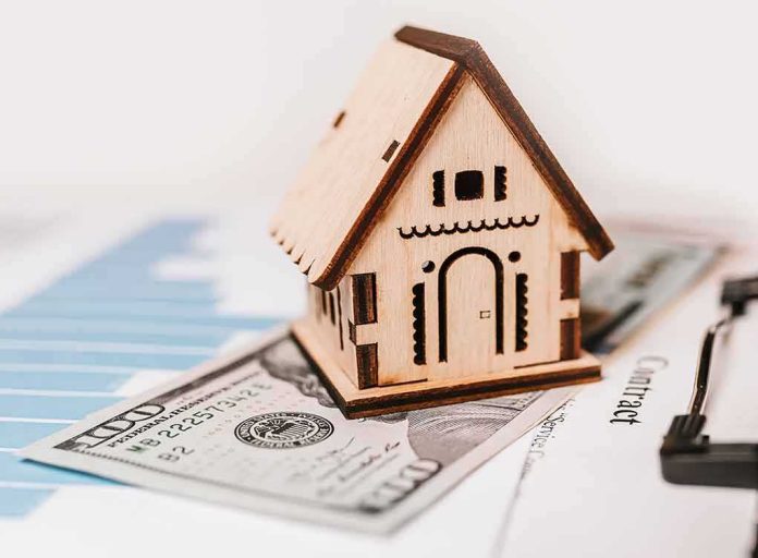 Wooden house model on money and contract papers