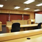 Sovereignty Showdown: ICC vs. America Interior view of an empty courtroom with wooden furniture and American flags