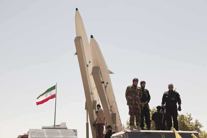 shutterstock_681421708 soldiers stand beside large missiles at outdoor display