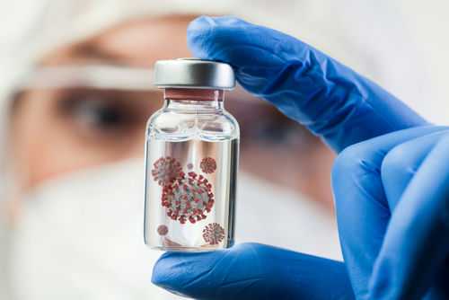virus-sample1882992490 Gloved hand holds vial with virus illustration inside