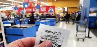 Walmart Slowdown Sparks Wallet Worries Hand holding a store receipt at a supermarket checkout area