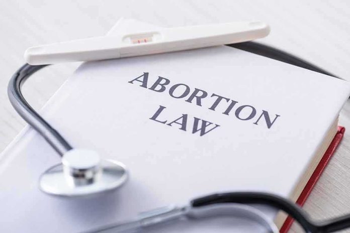 Pregnancy test and stethoscope on a book titled Abortion Law