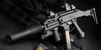 Silencer Registry Stumbles—What’s Left? Submachine gun with suppressor and magazines on dark surface