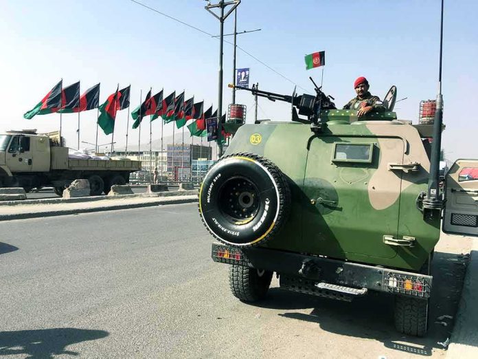 Armored military vehicle with soldier manning a mounted gun on city street