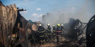 Refinery Chaos Sparks Gas Lines Across Russia Firefighters amid twisted metal and smoke at a disaster site