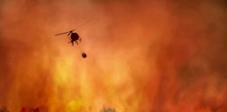 Tourist Artery Shut—Chaos Along Coast Helicopter fights massive wildfire over burning forest