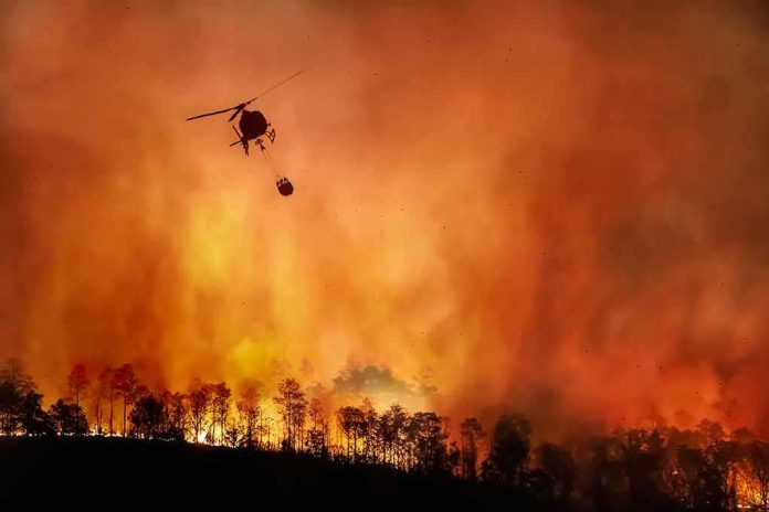shutterstock_1810018291 Helicopter fights massive wildfire over burning forest
