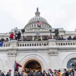 Protesters gathered on the steps and balcony of a domed government building