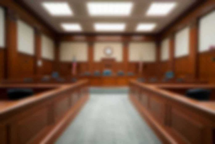 shutterstock_2324977165 Empty courtroom with wooden benches and judge's bench