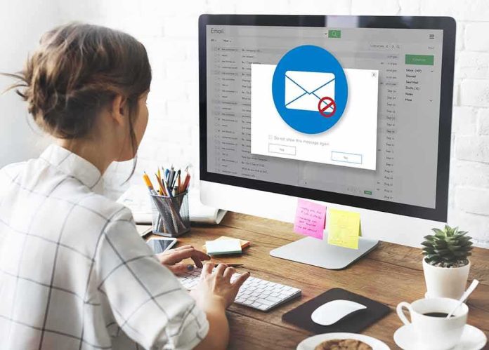 Woman using desktop computer with email warning popup