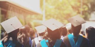 Nationwide Showdown: Who Sets Tuition Rules? Graduates in caps and gowns walking at an outdoor ceremony