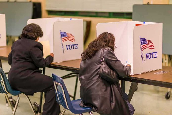 shutterstock_1046168689 Voters filling out ballots at polling booths