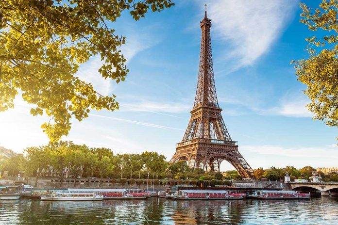 shutterstock_112137761 Eiffel Tower in Paris with boats on the river and green trees