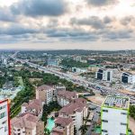 Big Tech Deal Unravels — Renters Feel It Aerial view of a city with highways and modern buildings under cloudy sky