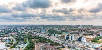 Aerial view of a city with highways and modern buildings under cloudy sky