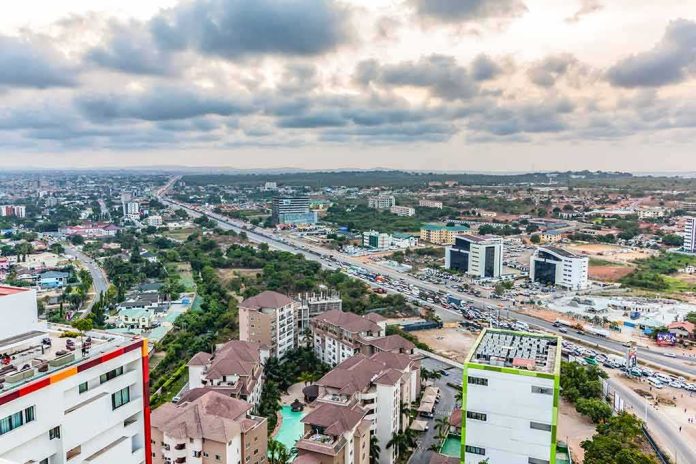 Aerial view of a city with highways and modern buildings under cloudy sky