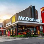 McDonald's restaurant exterior with drive-thru at sunset
