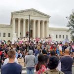 49,641 Votes Tip a Nation David Givens at a large protest outside a neoclassical courthouse