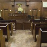Ministry Money, Multi-State Abuse Trail Interior view of an empty courtroom with wooden benches and a judges bench
