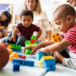Doctors Warn: Kids Caught In Crossfire Karyn Polito with toddlers building blocks on a play mat