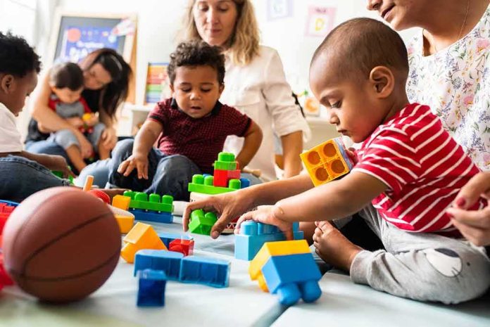 shutterstock_1247691913 Karyn Polito with toddlers building blocks on a play mat