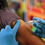 Healthcare worker administering vaccine in upper arm