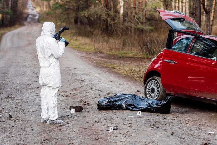 shutterstock_1344607811 forensic investigator photographing crime scene near red car on forest road