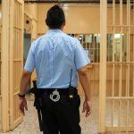 corrections officer walking through prison corridor