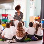 Paris Nursery Horror Sparks Citywide Probe Teacher reading a book to a group of young students on the classroom floor