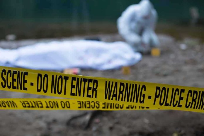 shutterstock_1474746275 Crime scene with police tape and forensic investigator