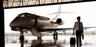 A Legendary American Pilot Reveals His Diagnosis Pilot walking with suitcase beside private jet in hangar