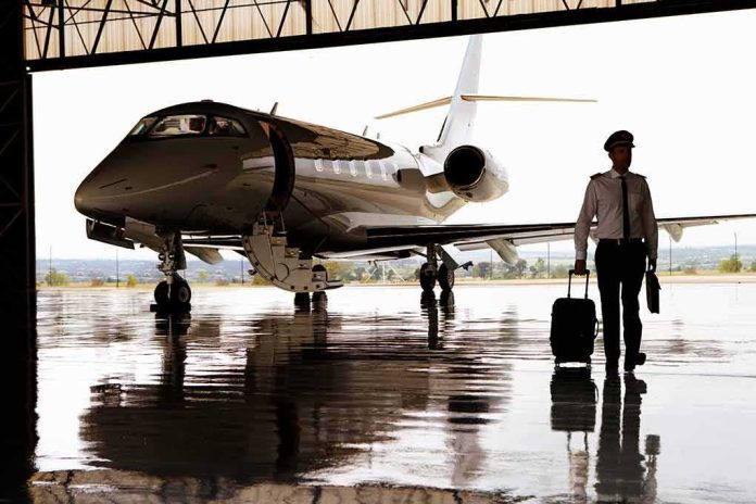 shutterstock_1586690725-2 Pilot walking with suitcase beside private jet in hangar