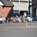 Stadium Sweep Dumps Lives In Trash Homeless encampment with tents along a city street