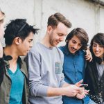 Frat House Chaos: Screenshot Sparks Reboot Group of friends looking at a smartphone