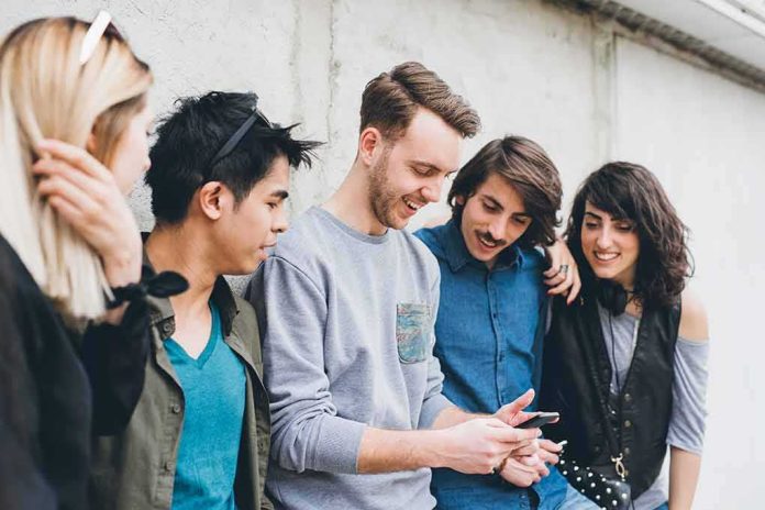 shutterstock_1908675214 Group of friends looking at a smartphone